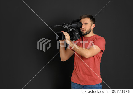 Operator with professional video camera on black background 89723976