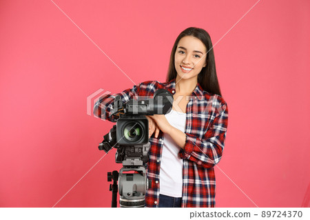 Operator with professional video camera on pink background 89724370