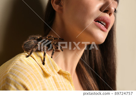 Young woman with tarantula on beige background, closeup. Arachnophobia (fear of spiders) 89724757