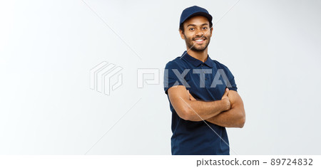 Delivery Concept - Handsome African American delivery man crossed arms over isolated on Grey studio Background. Copy Space. 89724832