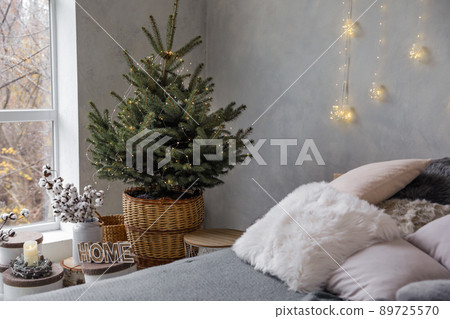 Little Christmas tree with fairy lights in bedroom interior 89725570