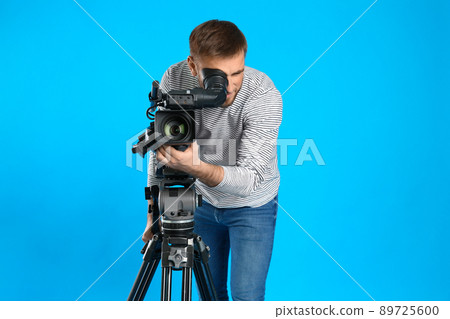 Operator with professional video camera on blue background 89725600