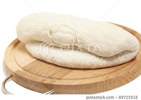 Fresh yeast dough on cutting board isolated on white background. Fresh yeast dough on cutting board isolated on white background. 89725818