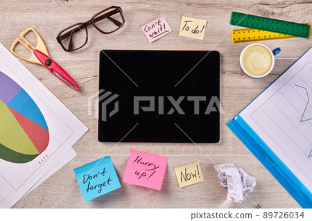 Top view tablet with blank screen and stationery accessories. 89726034