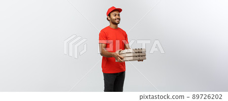 Delivery Concept - Portrait of Handsome African American Pizza delivery man. Isolated on Grey studio Background. Copy Space. 89726202
