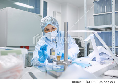 A female scientist processes the material in a clean room A female scientist processes the material in a clean room 89726593