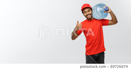 Delivery Concept - Handsome African American delivery man holding water tank. Isolated on Grey studio Background. Copy Space. 89726874