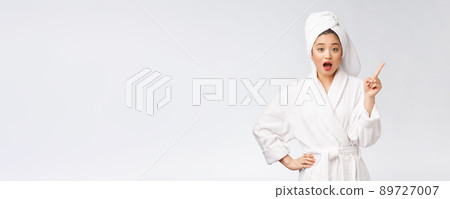 Beauty portrait of young woman showing and pointing finger to empty copy space, asian beauty in bathrobe. 89727007