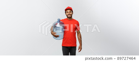 Delivery Concept - Handsome African American delivery man holding water tank. Isolated on Grey studio Background. Copy Space. 89727464