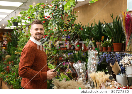 Male business owner with clipboard in his flower shop Male business owner with clipboard in his flower shop 89727880