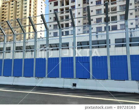 SELANGOR, MALAYSIA - JULY 18, 2020: Noise barriers are installed along the vehicle lane bordering the residence to prevent noise pollution to the surrounding locals. 89728163