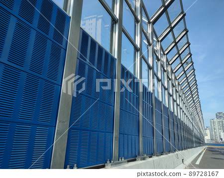 SELANGOR, MALAYSIA - JULY 18, 2020: Noise barriers are installed along the vehicle lane bordering the residence to prevent noise pollution to the surrounding locals. 89728167