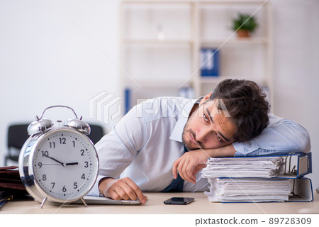 Young male employee in oversleeping concept Young male employee in oversleeping concept 89728309