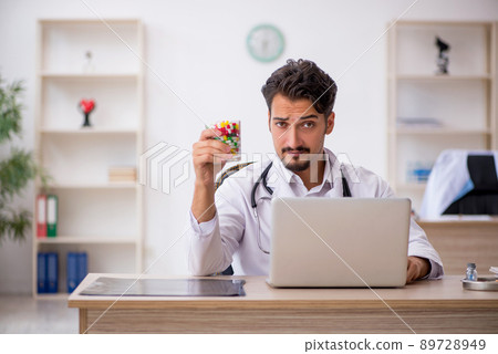 Young male doctor working in the clinic Young male doctor working in the clinic 89728949