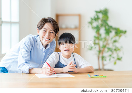 Parents and children (mother and child) doing homework together in the living room 89730474