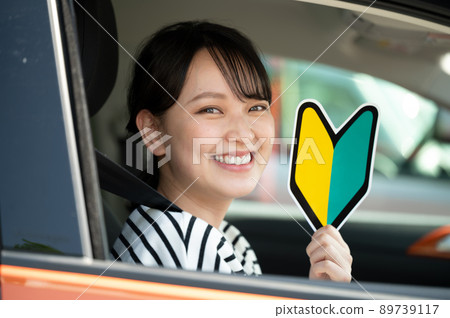 一位微笑的年輕女子,駕駛座上有初學者標記 一位微笑的年輕女子,駕駛座上有初學者標記 89739117