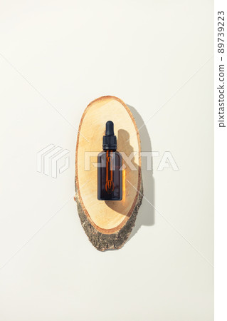 Amber glass bottle on wooden podium, white background. Natural cosmetic products packaging design template, branding Amber glass bottle on wooden podium, white background. Natural cosmetic products packaging design template, branding 89739223