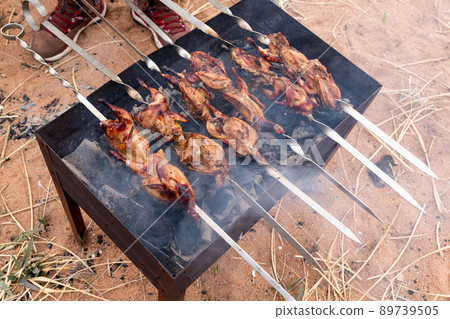 Cooking marinated quails on skewers, on the grill Cooking marinated quails on skewers, on the grill 89739505