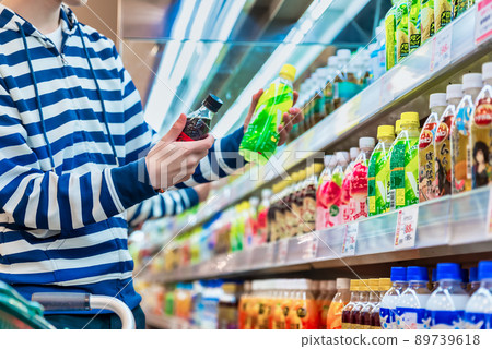 Image cut of a young man buying carbonated drinks at a supermarket 89739618
