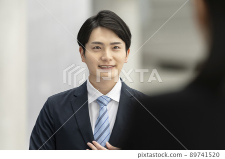 A young man in a suit who speaks with a smile Interview / interview / business negotiation image 89741520