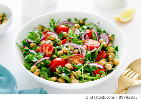 Vegetarian chickpea salad with tomatoes, arugula, parsley, spinach and red onion. Healthy food, diet 89742915