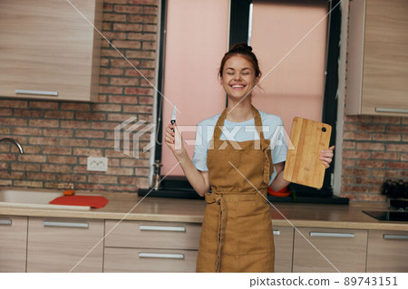 cheerful woman houses in the kitchen cutting board with knife apartments unaltered cheerful woman houses in the kitchen cutting board with knife apartments unaltered 89743151