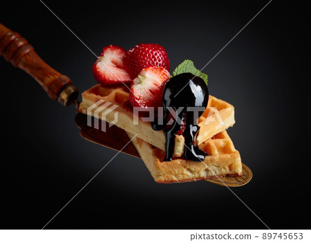 Belgian waffles with strawberries, mint and chocolate sauce. Belgian waffles with strawberries, mint and chocolate sauce. 89745653