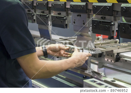 The operator working with hydraulic press brake bending machine. The operator working with hydraulic press brake bending machine. 89746952