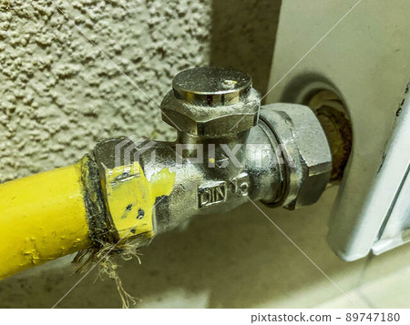 radiator for supplying heating to residential apartments. yellow battery pipe for hot water supply. plumbing communications 89747180