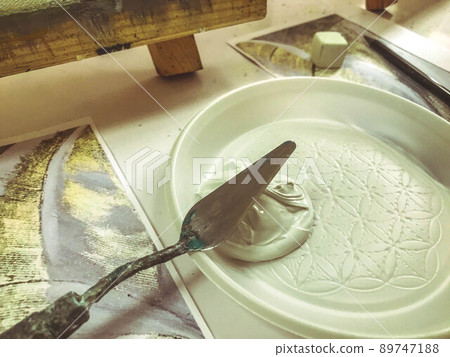 a palette for diluting paint for applying to canvas. white thick paint poured into a plastic mixing palette. special spatula for applying texture to canvas a palette for diluting paint for applying to canvas. white thick paint poured into a plastic mixing palette. special spatula for applying texture to canvas 89747188