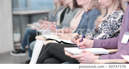 business group taking notes in clipbord sitting in the conference room. business group taking notes in clipbord sitting in the conference room. 89747376