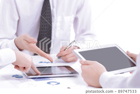 close up.the businessman uses a digital tablet to find partners.business concept close up.the businessman uses a digital tablet to find partners.business concept 89747533