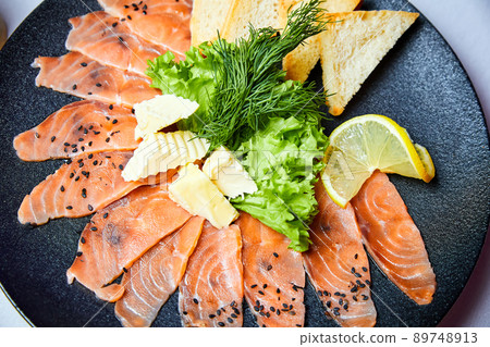 Lightly salted salmon slices with butter and wheat toasts 89748913