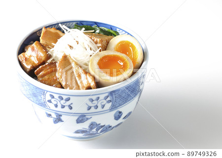 A picture of a pork kakuni bowl with a soft-boiled egg, spinach and white onions on a white background 89749326