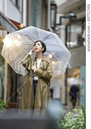 A young woman looking up at the sky with a vinyl umbrella A young woman looking up at the sky with a vinyl umbrella 89751309