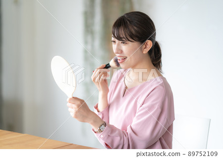 Woman doing make-up Woman doing make-up 89752109