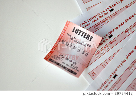 Red lottery ticket lies on pink gambling sheets with numbers for marking to play lottery. Lottery playing concept or gambling addiction. Close up Red lottery ticket lies on pink gambling sheets with numbers for marking to play lottery. Lottery playing concept or gambling addiction. Close up 89754412