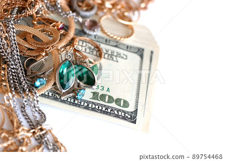 Many expensive golden and silver jewerly rings, earrings and necklaces with big amount of US dollar bills on white background. Pawnshop or jewerly shop Many expensive golden and silver jewerly rings, earrings and necklaces with big amount of US dollar bills on white background. Pawnshop or jewerly shop 89754468