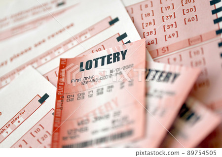 Red lottery ticket lies on pink gambling sheets with numbers for marking to play lottery. Lottery playing concept or gambling addiction. Close up Red lottery ticket lies on pink gambling sheets with numbers for marking to play lottery. Lottery playing concept or gambling addiction. Close up 89754505