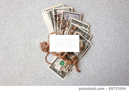 Many expensive golden jewerly rings, earrings and necklaces with big amount of US dollar bills with copy space. Pawnshop or jewerly shop 89755004