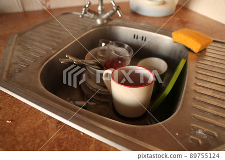 Stack of dirty dishes with food leftovers in the kitchen sink. Unwashed dishes Stack of dirty dishes with food leftovers in the kitchen sink. Unwashed dishes 89755124