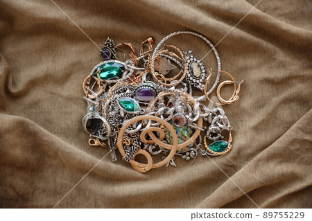 Bunch of stolen jewelry on military uniform cloth fabric. Looting by Russian soldiers in the Ukrainian cities during the Russian attack on Ukraine. Marauders and looters Bunch of stolen jewelry on military uniform cloth fabric. Looting by Russian soldiers in the Ukrainian cities during the Russian attack on Ukraine. Marauders and looters 89755229