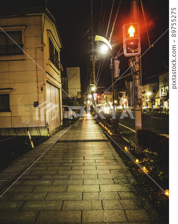 A landscape of candles lined up on the sidewalk 89755275