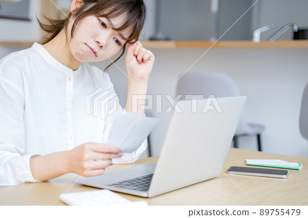 A woman holding a household account book 89755479