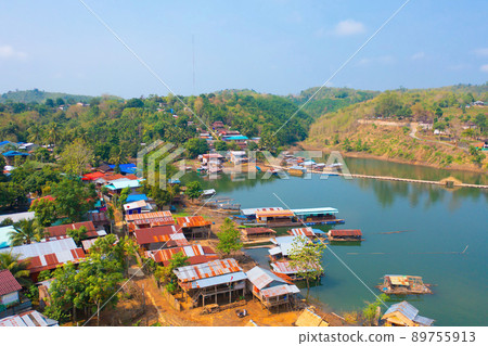 Aerial top view of residential local houses in Mon village, nature trees with lake or river, Kanchanaburi, Thailand in urban city town in Asia, buildings. 89755913