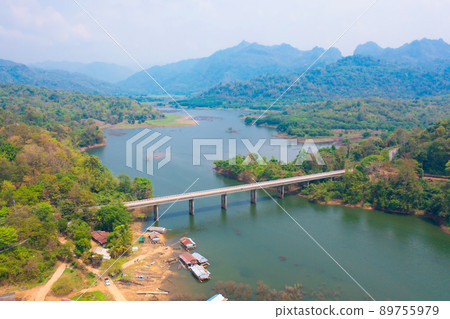 Aerial top view of Mon Bridge with residential local houses in Mon village, nature trees, Sangkhlaburi, Kanchanaburi, Thailand in urban city town in Asia, buildings. 89755979