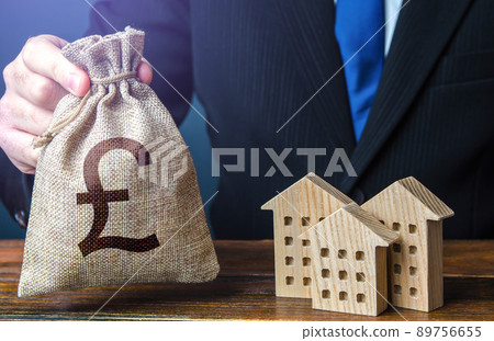 British pound sterling money bags and residential buildings figures. Taxes. Bank offer of mortgage loan. Rental business. Sale of housing. Buy. Investments in real estate and construction industry. 89756655