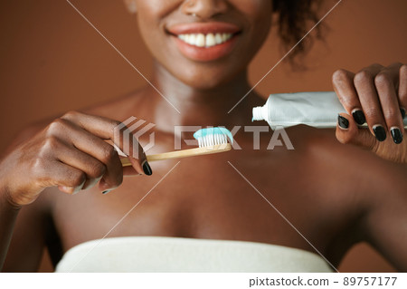 Woman Squeezing Toothpaste on Brush Woman Squeezing Toothpaste on Brush 89757177