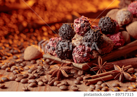 Chocolate truffles with cinnamon, anise, and coffee beans on a wooden table. Chocolate truffles with cinnamon, anise, and coffee beans on a wooden table. 89757315