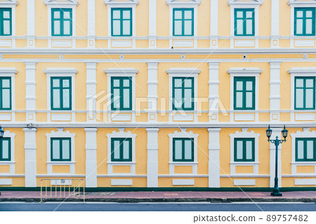 Yellow building with green window in vintage style on day with clear sky 89757482